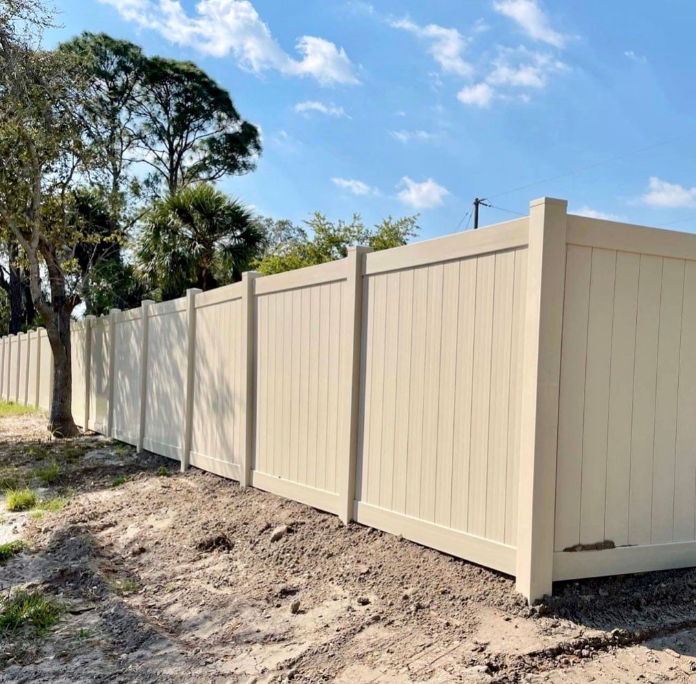 6 ft tan vinyl privacy fence with pyramid post caps on a residential lot